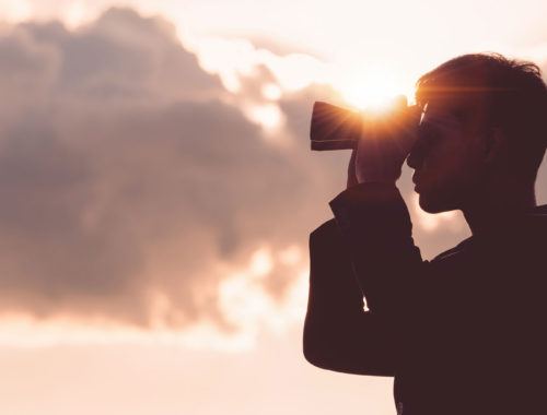 Man Holding Binoculars and looking/searching